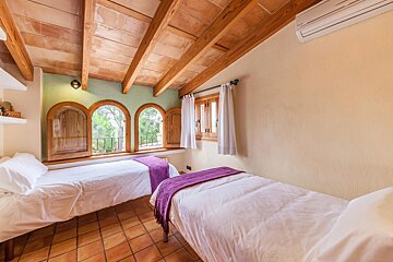 A bedroom with two beds and a purple blanket