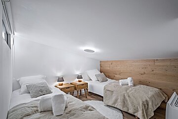 A bedroom with two beds and a mirror