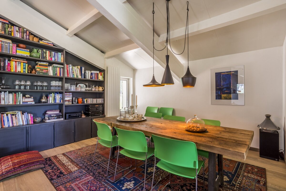 A dining room with a wooden table and green chairs
