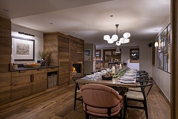 A dining room with a long table and chairs
