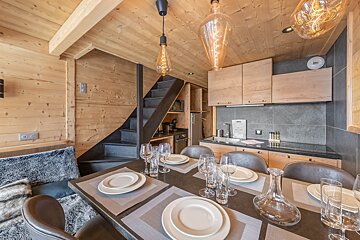 A dining room table with plates and glasses on it