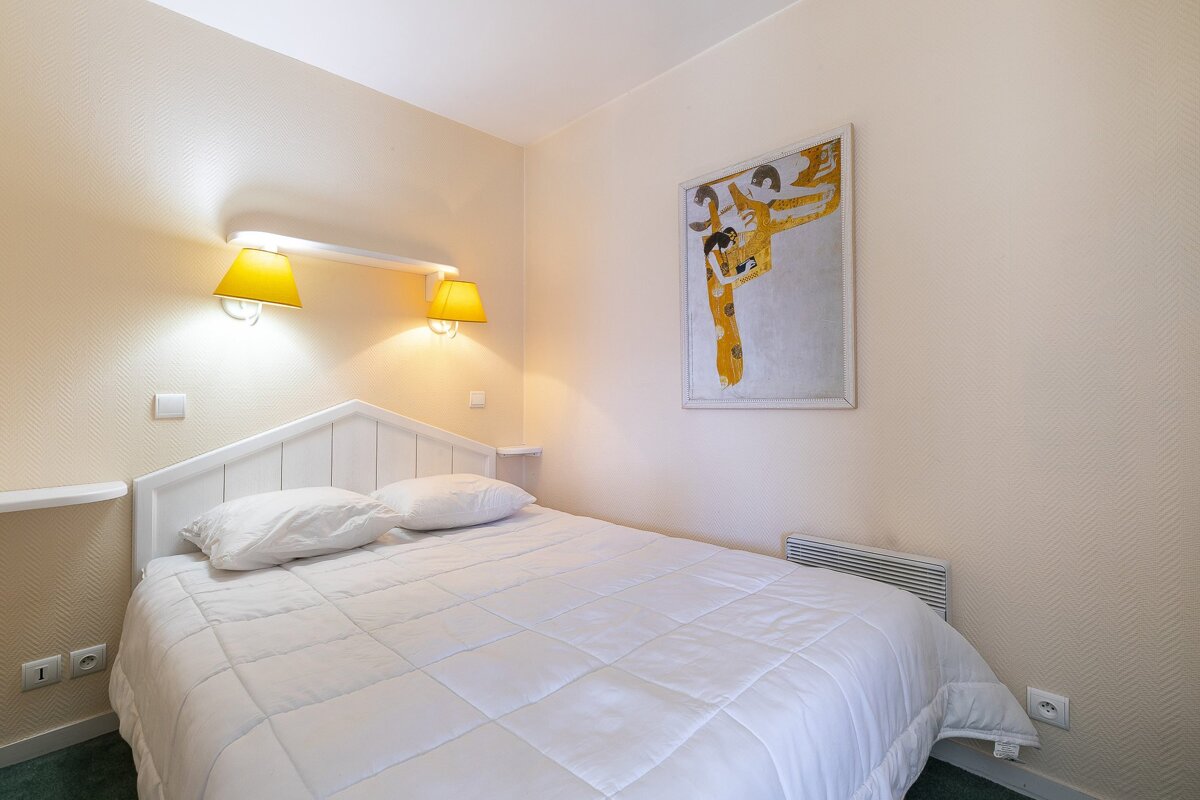 A bedroom with a bed and a picture on the wall