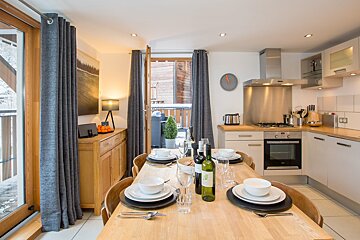 A kitchen with a clock above the stove that shows the time as 10:10