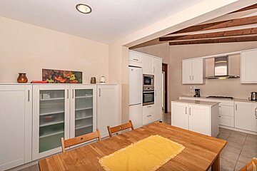A kitchen with white cabinets and a yellow table cloth