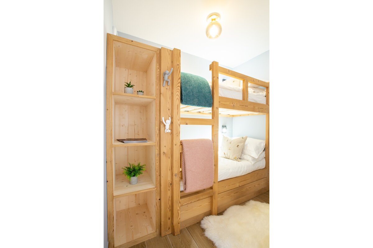 A bunk bed with a pink blanket on it