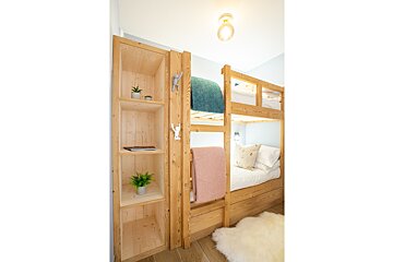 A bunk bed with a pink blanket on it