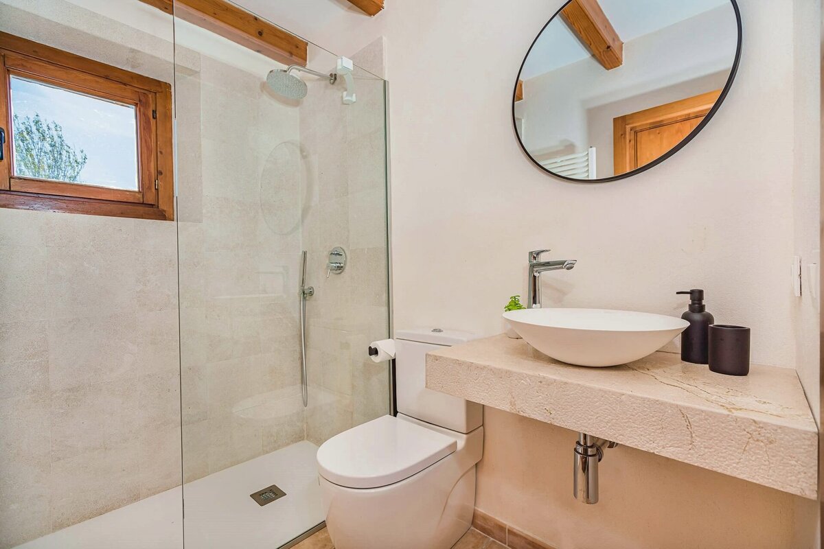 A bathroom with a toilet a sink and a shower