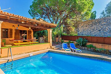 A large swimming pool with a house in the background