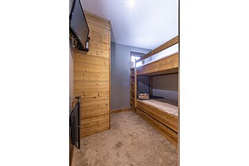A bedroom with a painting of bison on the wall above the bed