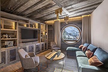 A living room with a round window and a flat screen tv