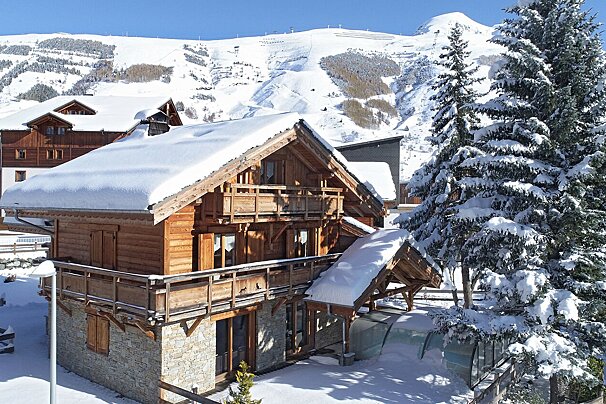 A snowy house with a mountain in the background