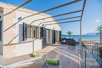 A balcony with a view of the ocean and mountains