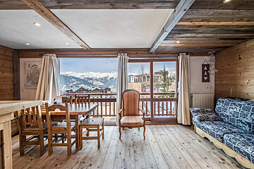 A living room with a couch and a table with a view of the mountains