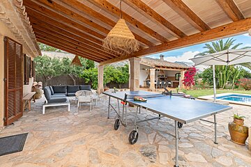 A ping pong table sits under a wooden roof