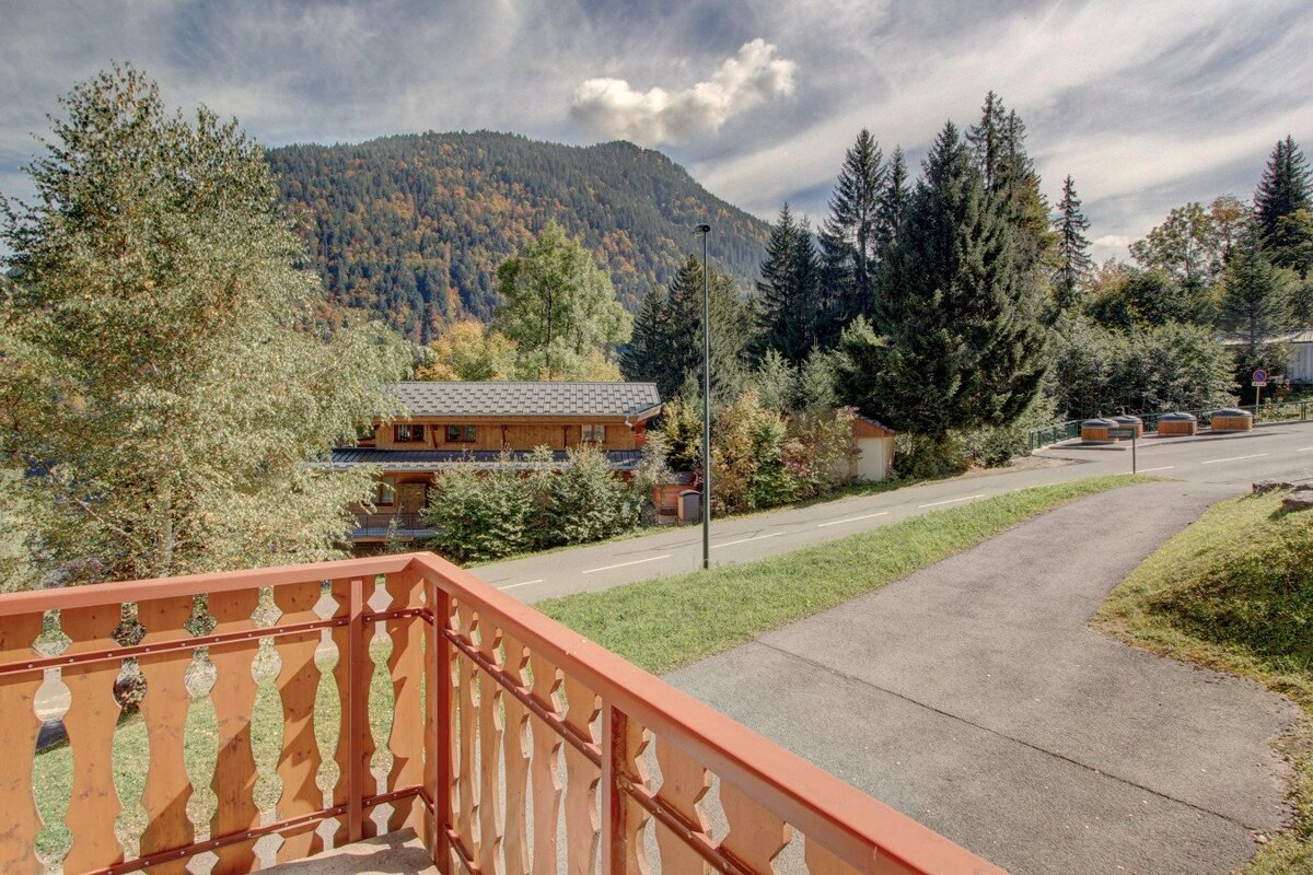 A balcony with a view of mountains and trees
