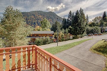 A balcony with a view of mountains and trees