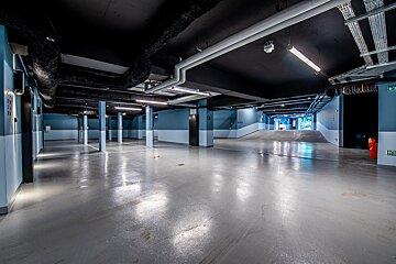 An empty parking garage with a green exit sign