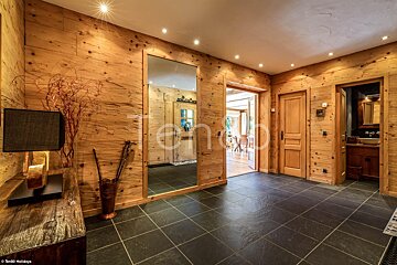 A hallway with wooden walls and a large mirror