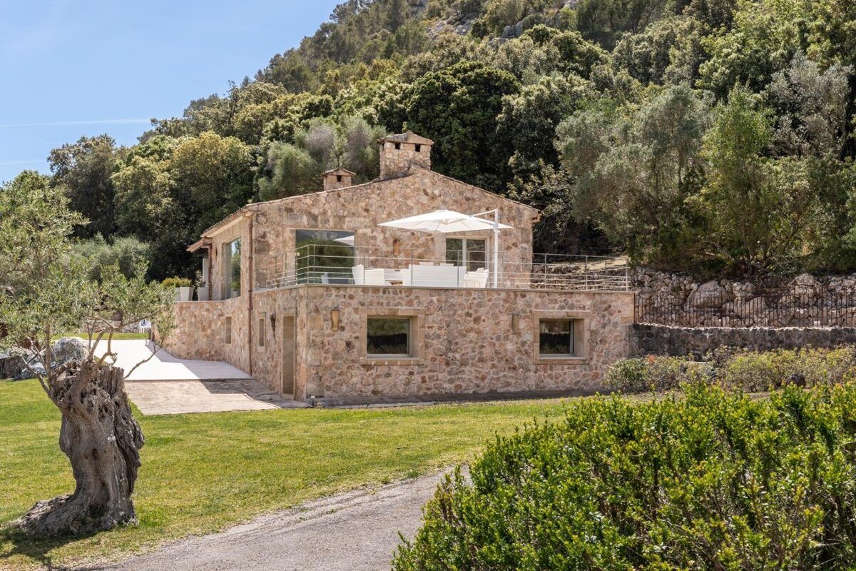 A stone house with a white umbrella in front of it