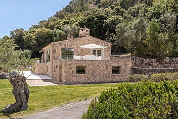 A stone house with a white umbrella in front of it