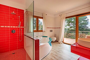 A bathroom with red tiles and a jacuzzi tub