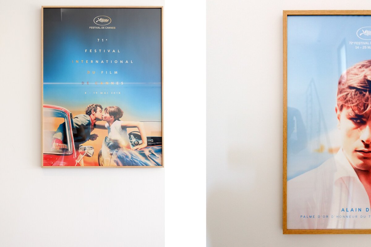 A poster for the festival de cannes is framed on a white wall