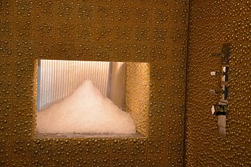 A pyramid of ice is visible through a hole in a wall