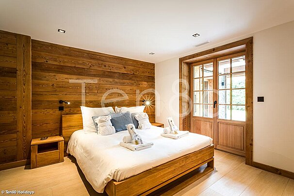 A bedroom with a bed and a window with the word tend on the wall