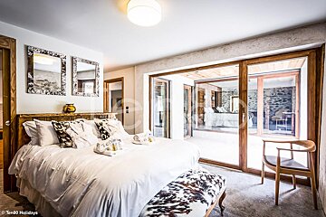 A bedroom with a large bed and sliding glass doors