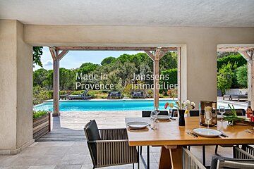 A dining room with a table and chairs and the words made in provence on the wall
