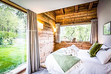 A bedroom with a bed and a large window