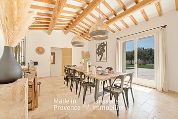 A dining room with a table and chairs made in provence by immobilier