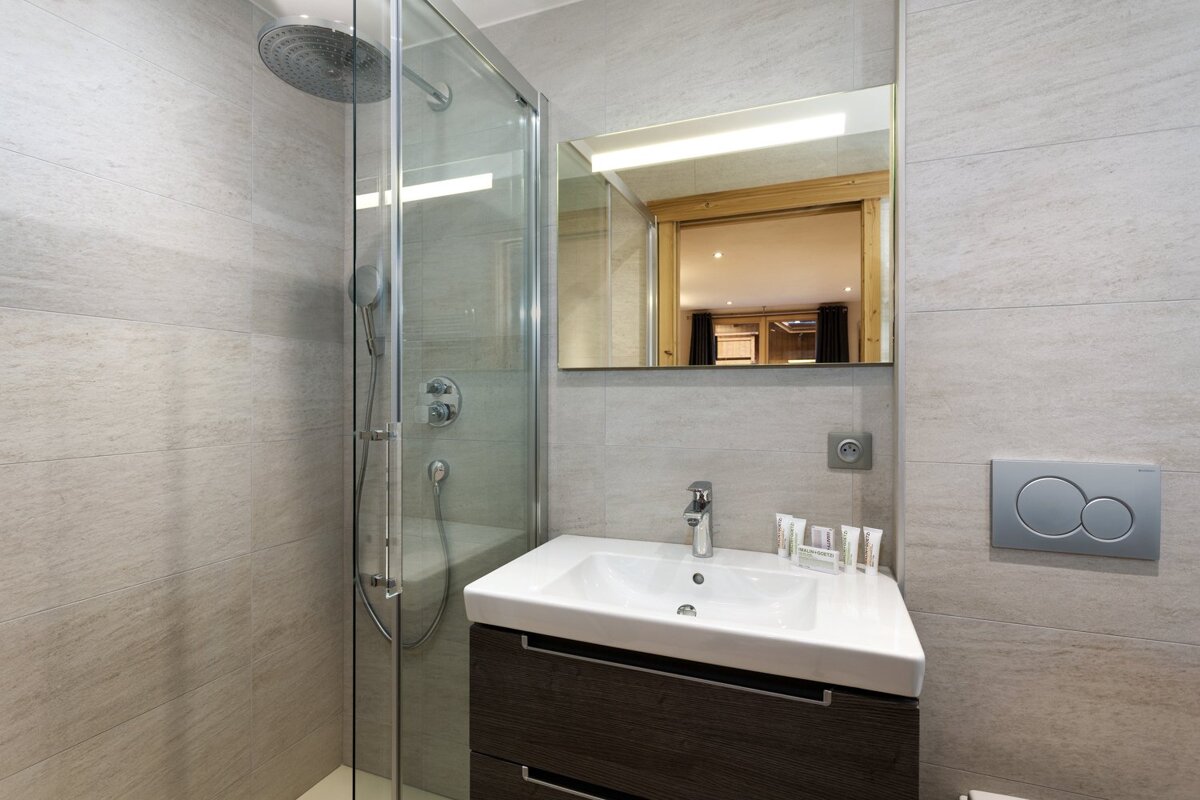 A bathroom with a sink a mirror and a shower