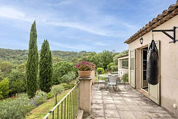 A boxing bag hangs from the roof of a house