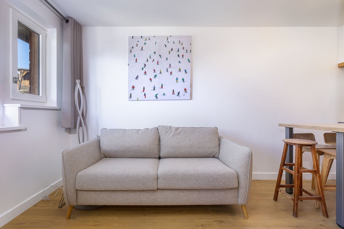 A painting of skiers hangs above a couch in a living room