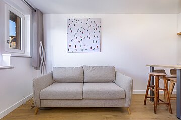 A painting of skiers hangs above a couch in a living room