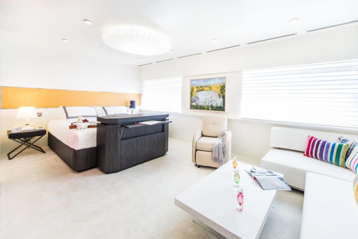 A bedroom with a large bed and a painting on the wall