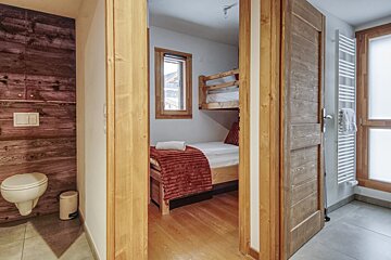 A bathroom with a toilet and a bunk bed