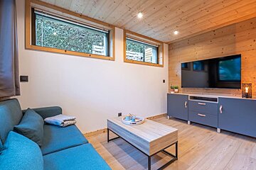 A living room with a blue couch and a flat screen tv