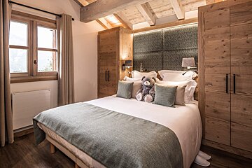 A bedroom with a large bed and a window