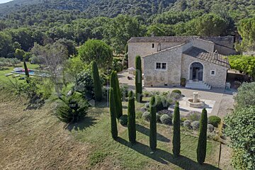 An aerial view of a house with a fountain in front of it