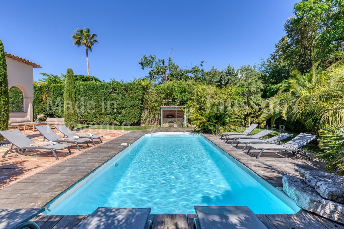 A large swimming pool is surrounded by chairs and a sign that says made in france