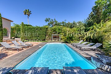 A large swimming pool is surrounded by chairs and a sign that says made in france