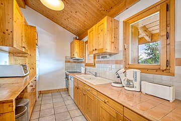 A kitchen with wooden cabinets and appliances including a coffee maker