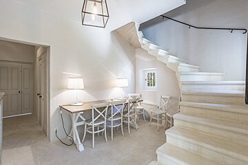 A staircase leading up to a room with a desk and chairs
