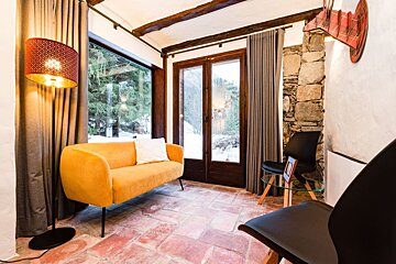 A living room with a yellow couch and a lamp