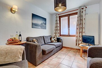 A living room with a couch and two bottles of wine