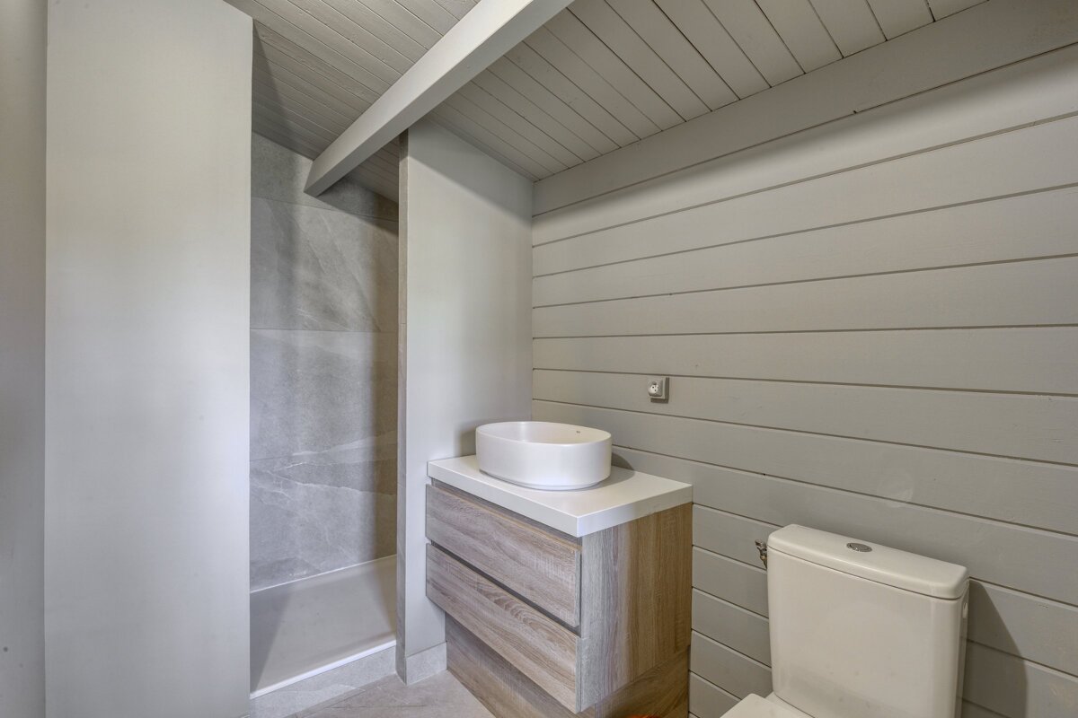 A bathroom with a toilet a sink and a shower