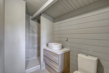 A bathroom with a toilet a sink and a shower