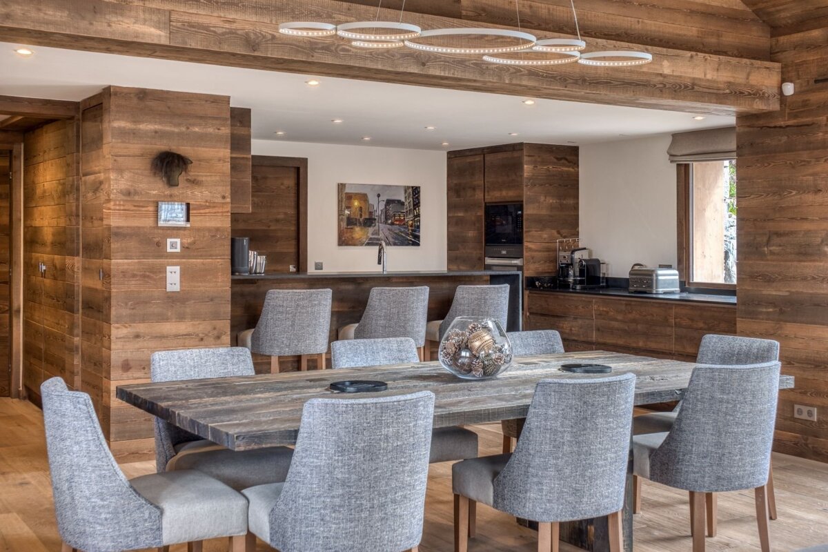 A dining room with a wooden table and chairs